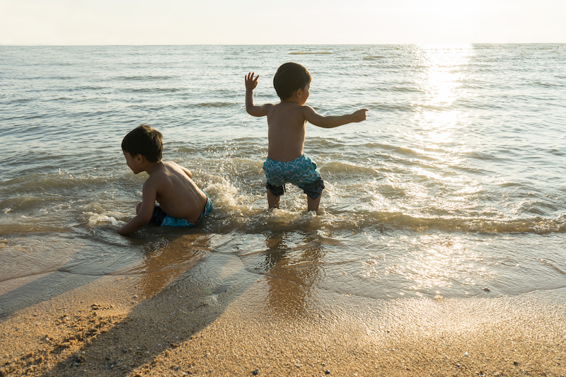 Deux enfants qui jouent dans l'eau sur la plage - Grazie Gigi